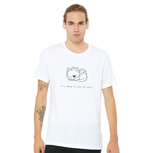 Man wearing white It's Okay To Not Be Okay tee with minimalist Grix dragon line art