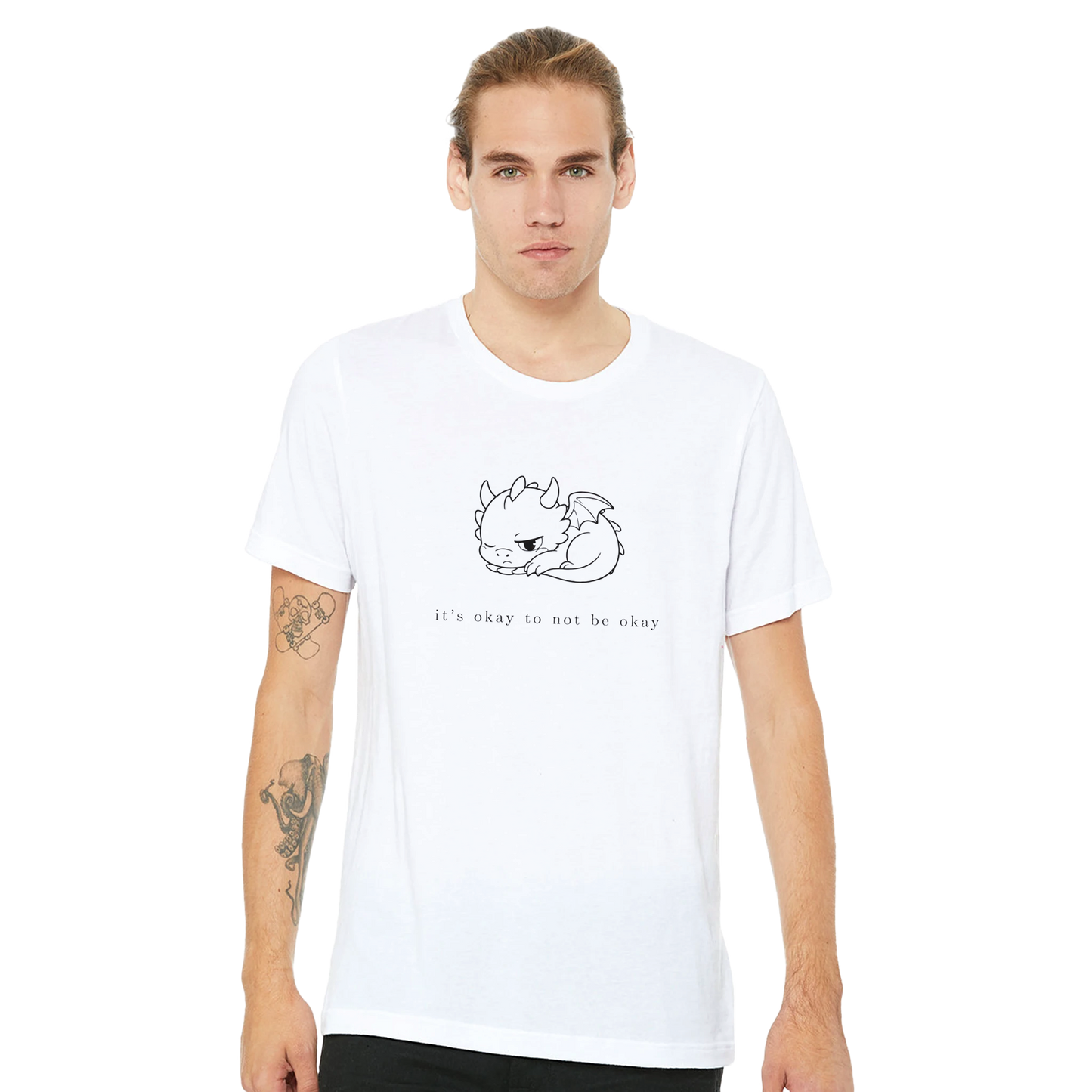 Man wearing white It's Okay To Not Be Okay tee with minimalist Grix dragon line art
